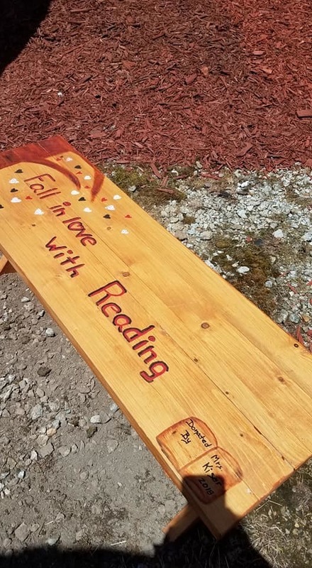 Bench with "Fall in love with reading" painted on it